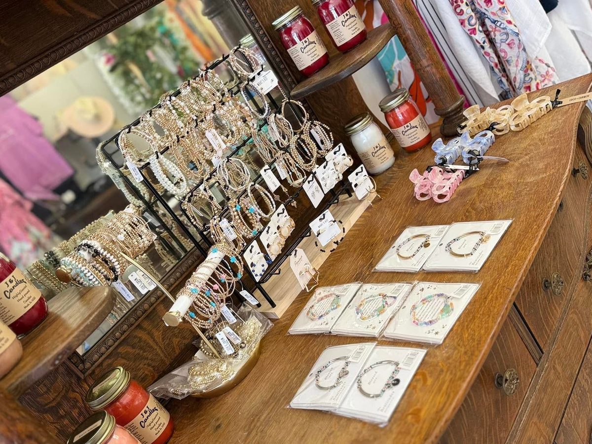 Jewelry, bracelets, claw clips and hand-poured candles displayed on an antique oak dresser