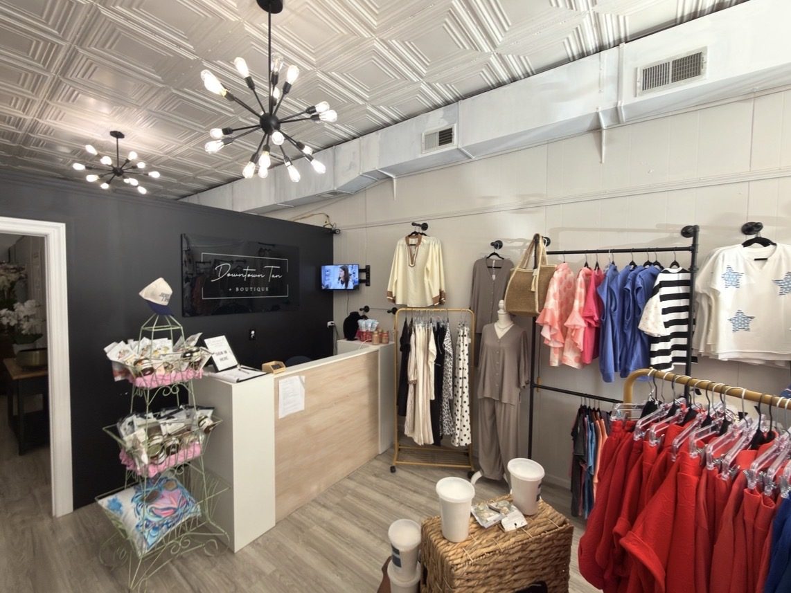 Boutique interior with checkout counter, sputnik chandeliers and clothing racks